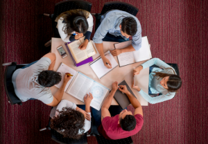 Group of college students studying together in a roundtable