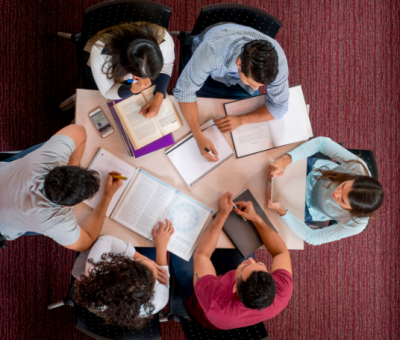 Group of college students studying together in a roundtable